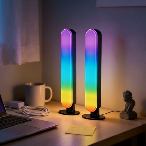 Zwei bunte LED-Lampen auf einem Schreibtisch.