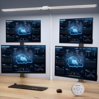 Vier Monitore mit Datenanzeigen auf einem Schreibtisch.