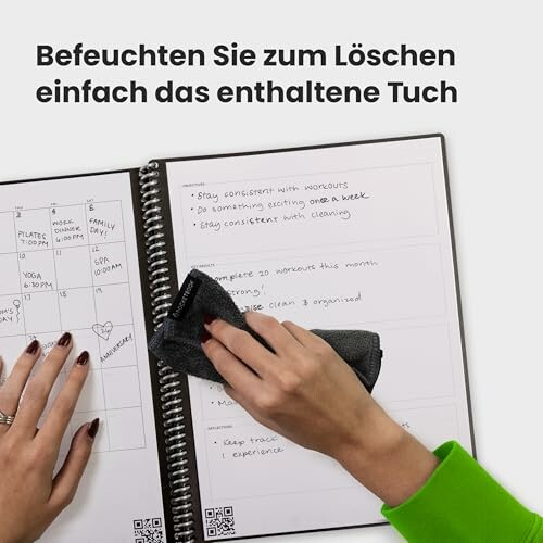 Person wischt ein wiederverwendbares Notizbuch sauber.